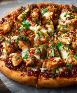 Chili Garlic Chicken Pizza topped with spicy garlic sauce and fresh herbs